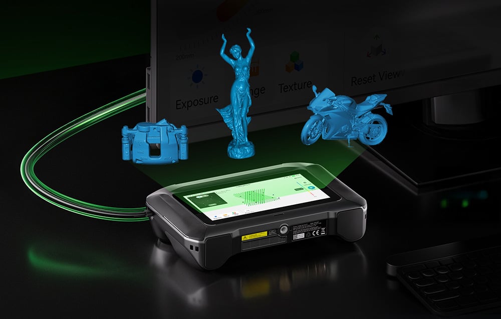 Skaner 3D Creality leżący na blacie, z holograficznie unoszącymi się nad nim niebieskimi modelami 3D różnych obiektów