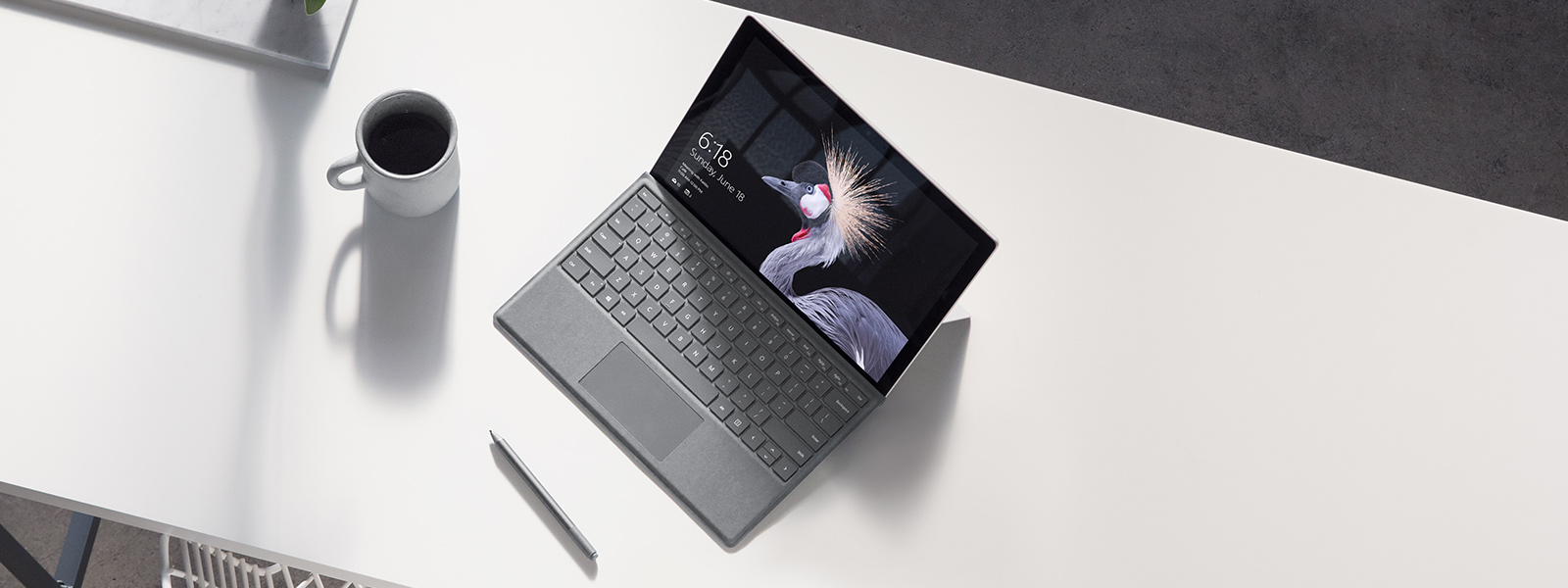 Obraz przedstawiający urządzenie Surface Pro na plaży z piórem Surface.
