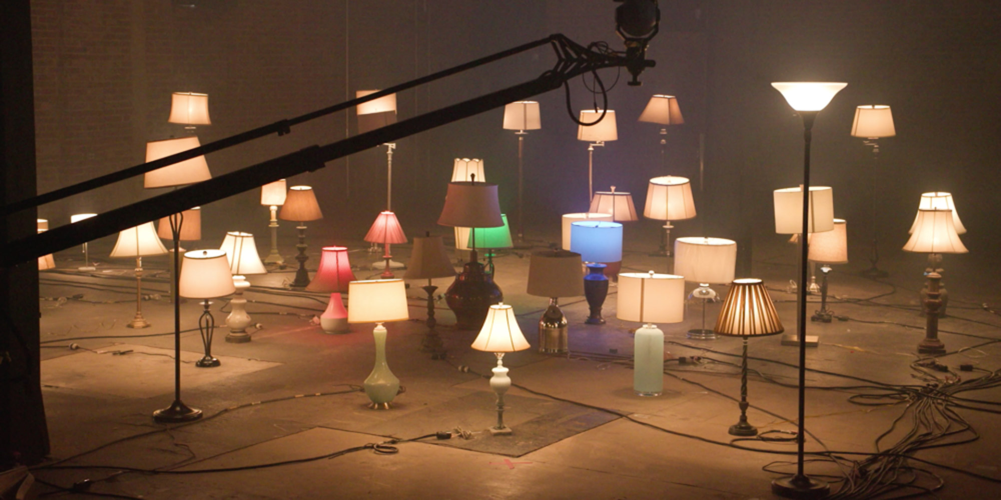 Kilkanaście lamp o różnych rozmiarach i stylu stojących na podłodze