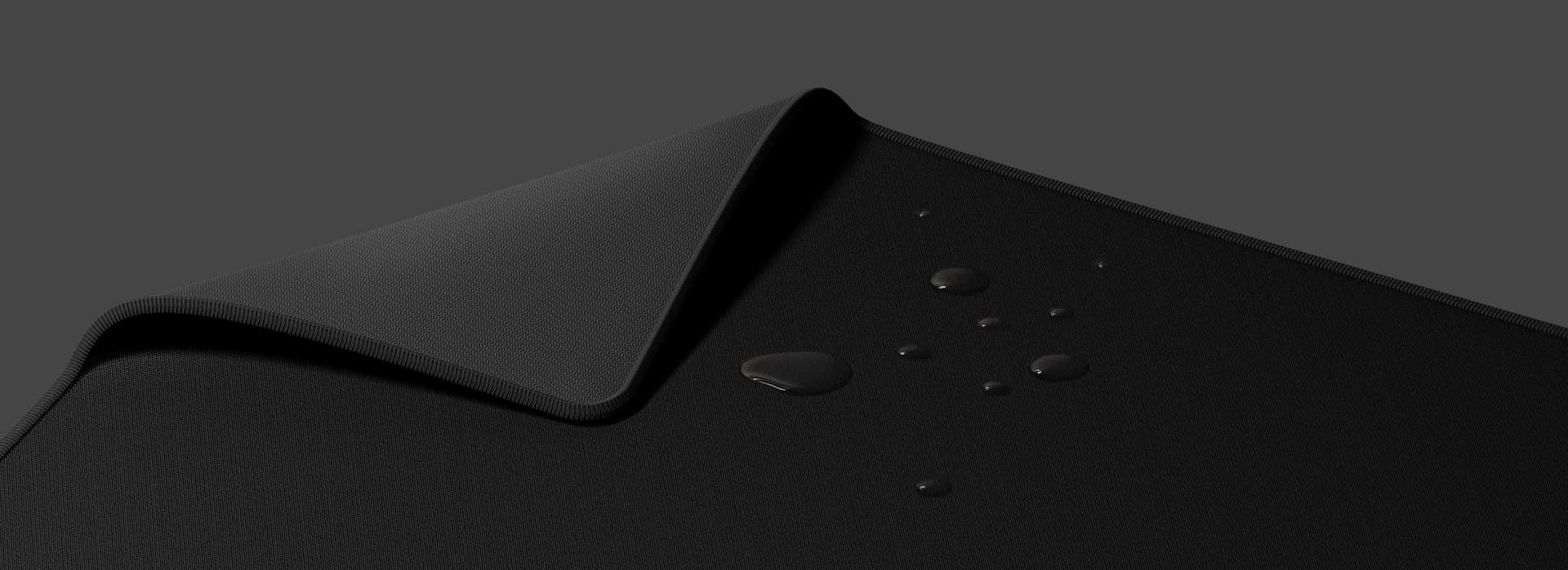 Czarna podkładka pod mysz dla graczy z teksturowaną powierzchnią i zawiniętą krawędzią, na której znajdują się krople wody.