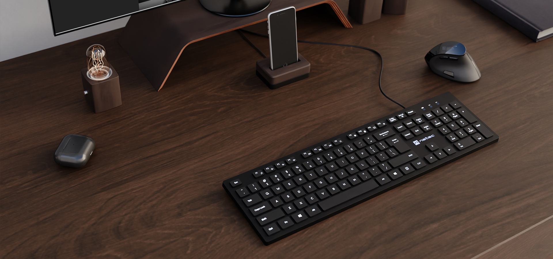 Smukła, czarna klawiatura multimedialna umieszczona na drewnianym biurku obok myszy i akcesoriów.