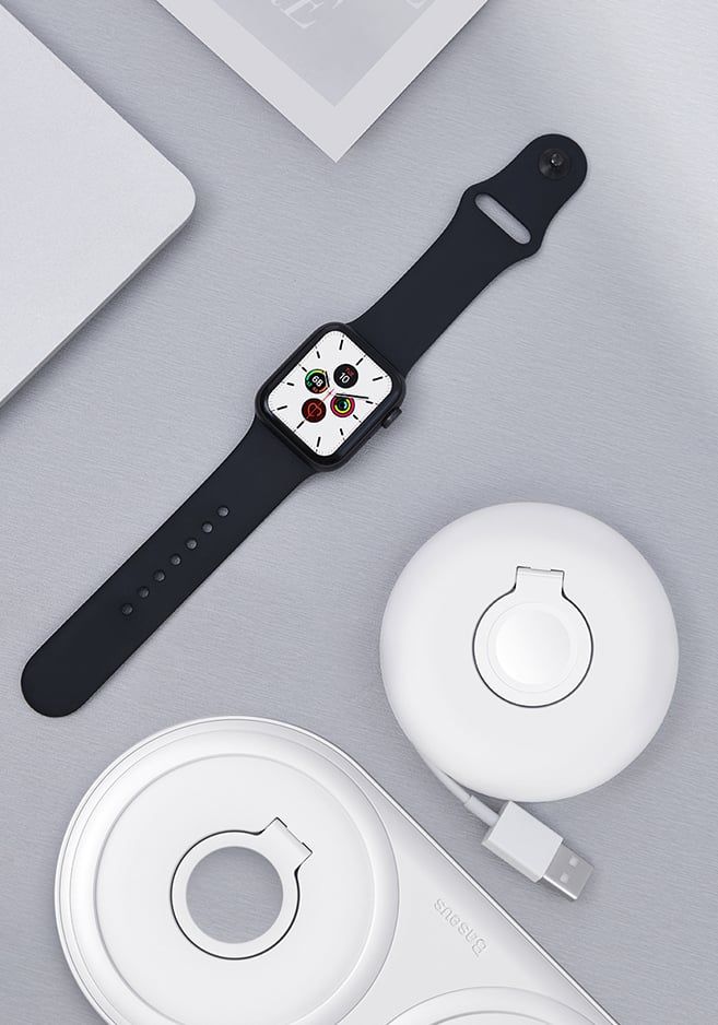 Smartwatch leżący przy organizerze na ładowarkę.