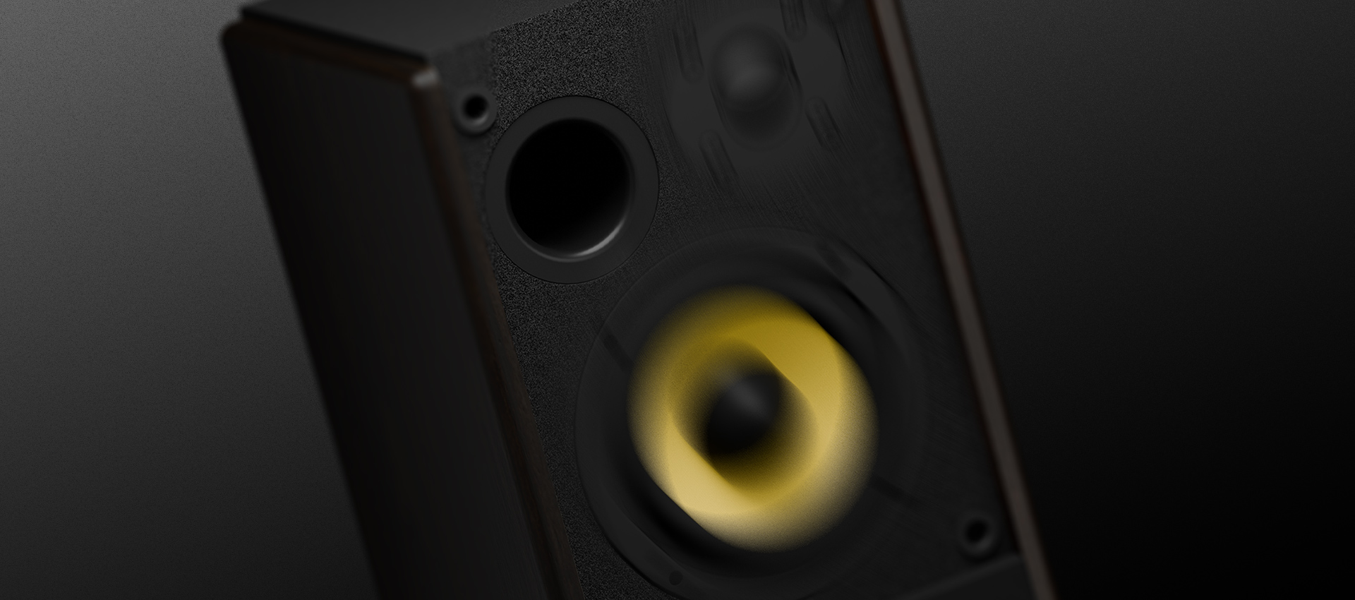 Kompaktowy głośnik z czarną obudową i żółtym stożkiem, z małym portem audio.