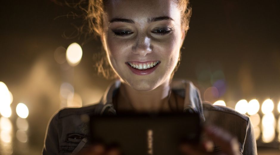 Dziewczyna korzystająca z telefonu Xperia E4 na zewnątrz w środku nocy