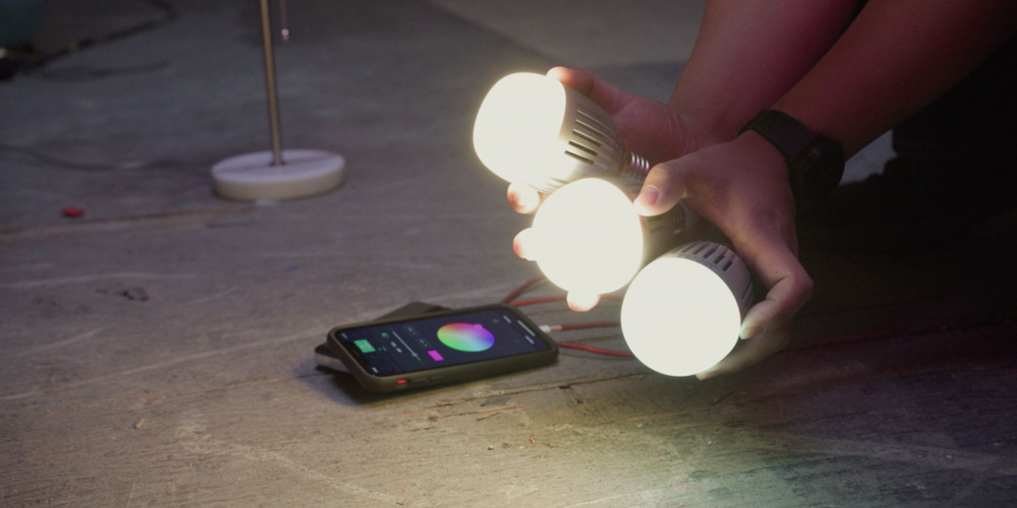 Trzy żarówki LED Aputure Accent B7c trzymane w dłoniach