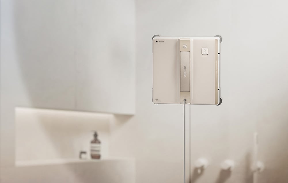 Robot do mycia okien zawieszony na uchwycie w jasnej łazience