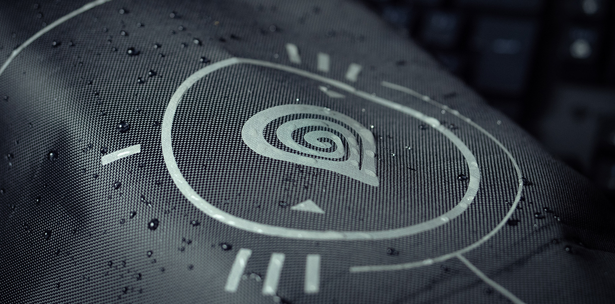 Zbliżenie na wodoodporną tkaninę ze spiralnym logo i grafiką, podkreślającą jej trwałość.