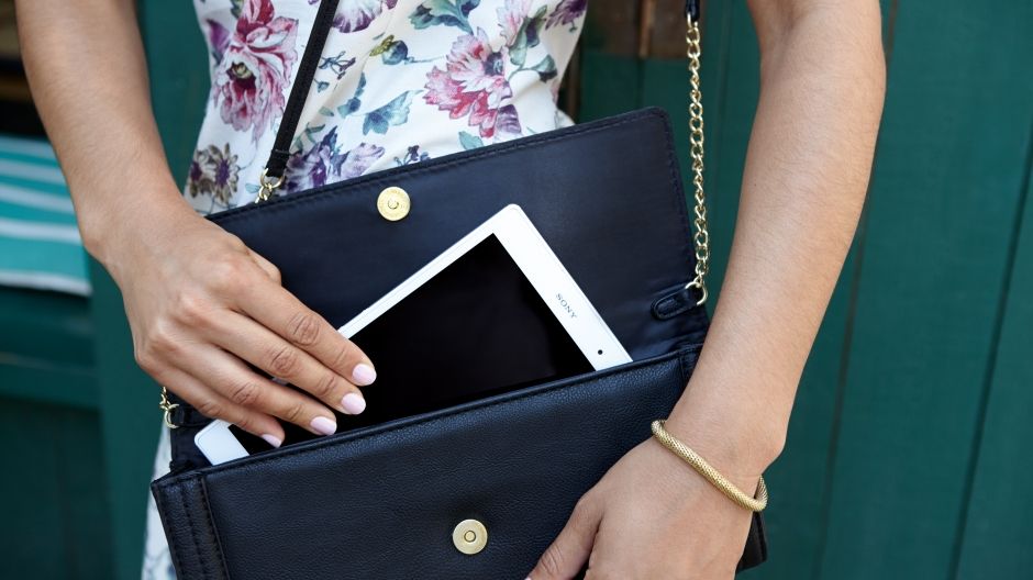 Zdjęcie osoby wkładającej urządzenie Xperia Z3 Tablet Compact do małej torebki