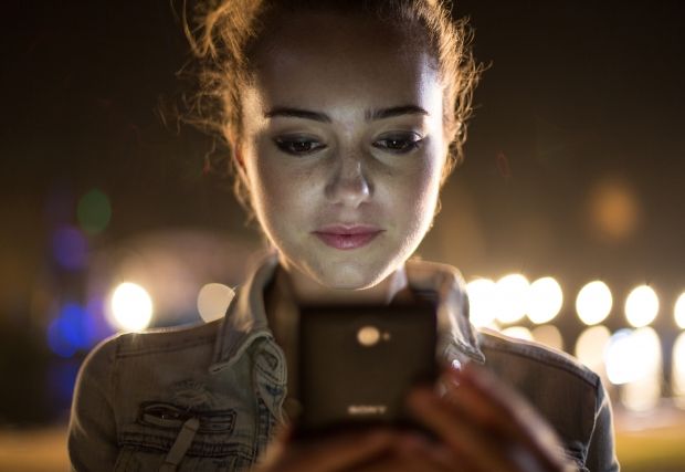Dziewczyna korzystająca z telefonu Xperia E4 w środku nocy