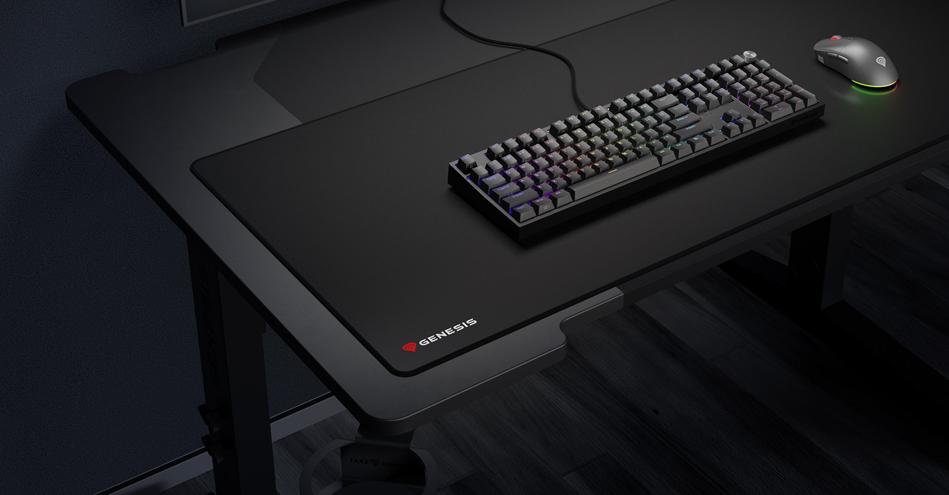 Duża podkładka pod mysz dla graczy z logo Genesis, umieszczona na biurku z klawiaturą i myszą. Rozmiar: 1100x450mm