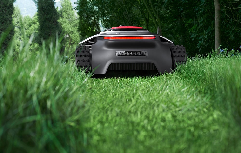 Robot koszący widziany z niskiej perspektywy wśród wysokiej trawy