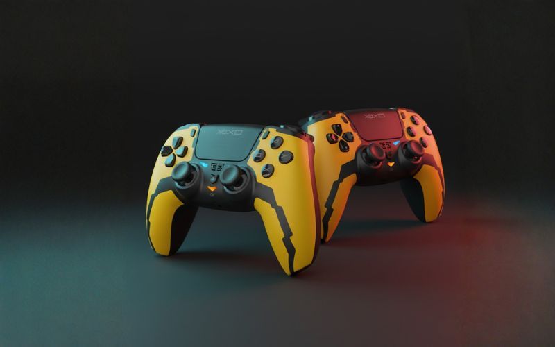 Dwa kontrolery YAXO Hornet Fury Elite w kolorze żółtym i pomarańczowym ustawione obok siebie na ciemnym tle