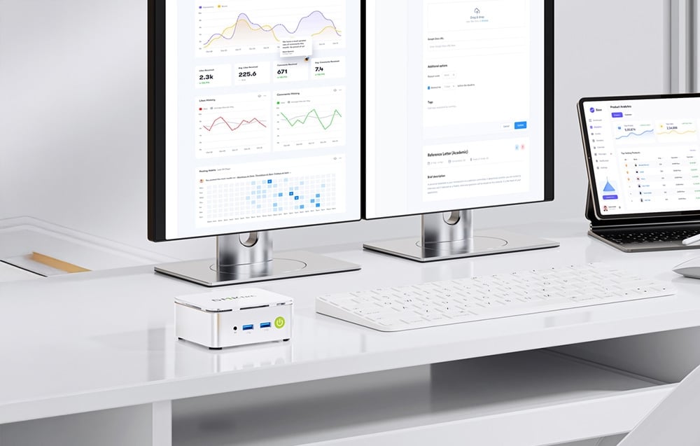 2 monitory i laptop stoją na biurku obok klawiatury i Mini PC.
