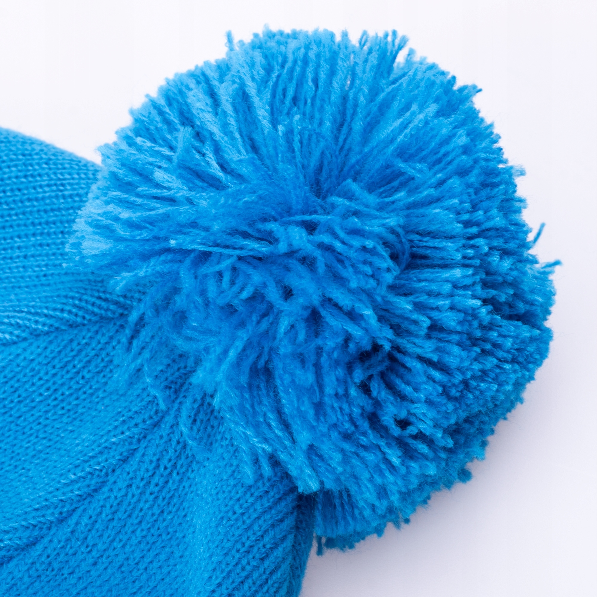 Uroczy pompon i delikatne logo marki