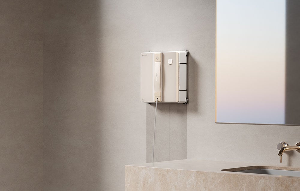 Robot czyszczący zamocowany na ścianie w łazience nad marmurowym blatem