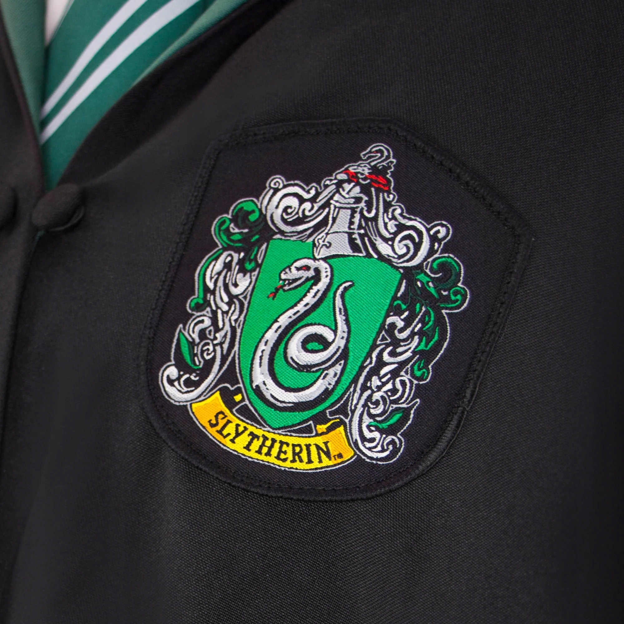 Zestaw zawiera kieszeń na różdżkę i naszywkę Slytherinu
