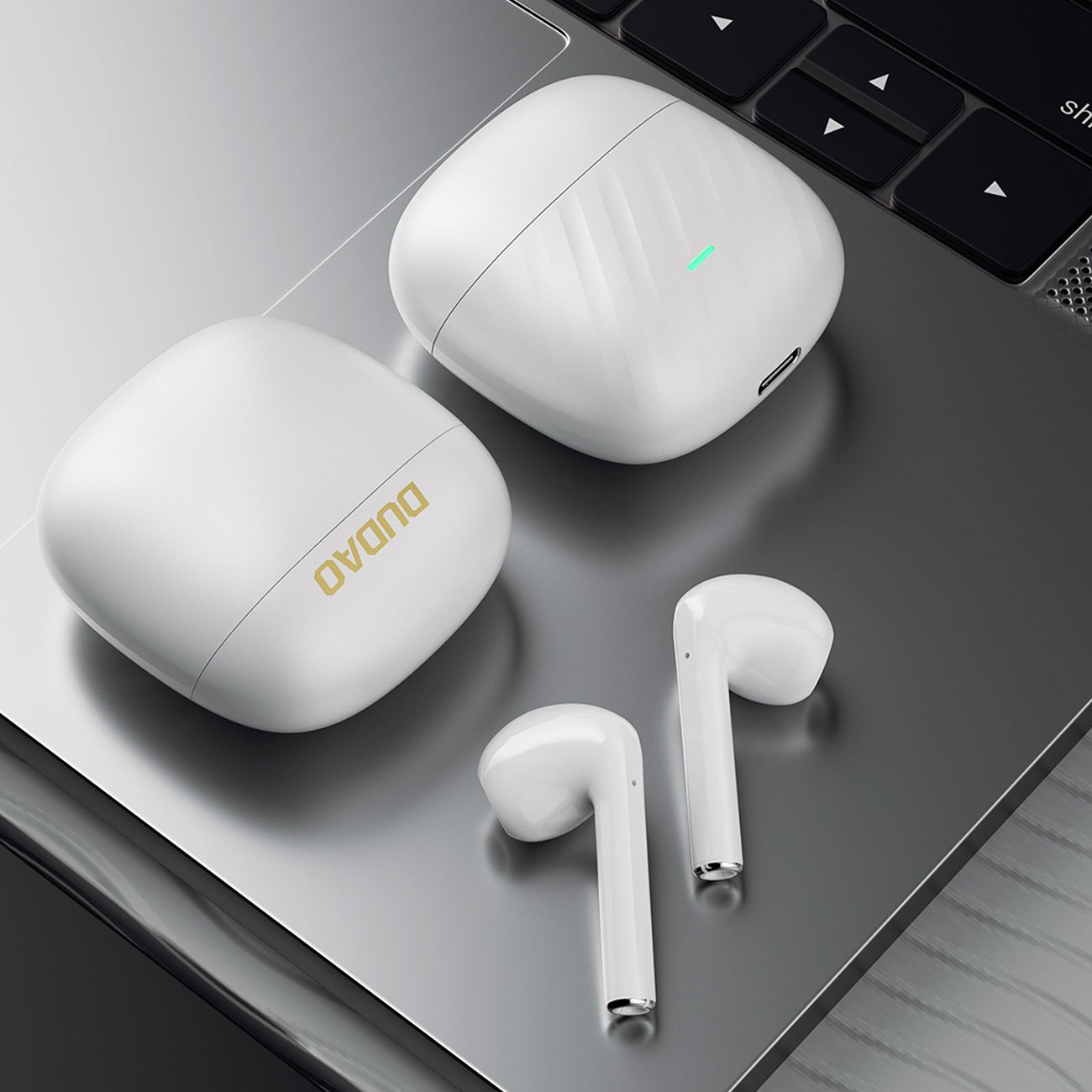 MacBook Pro na których leżą słuchawki bezprzewodowe Dudao U14+ TWS wraz z etui