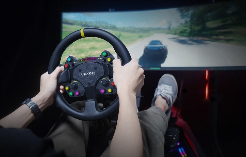 Mężczyzna grający w grę przy użyciu kierownicy gamingowej MOZA RACING; w tle ekran przedstawiający pojazd.