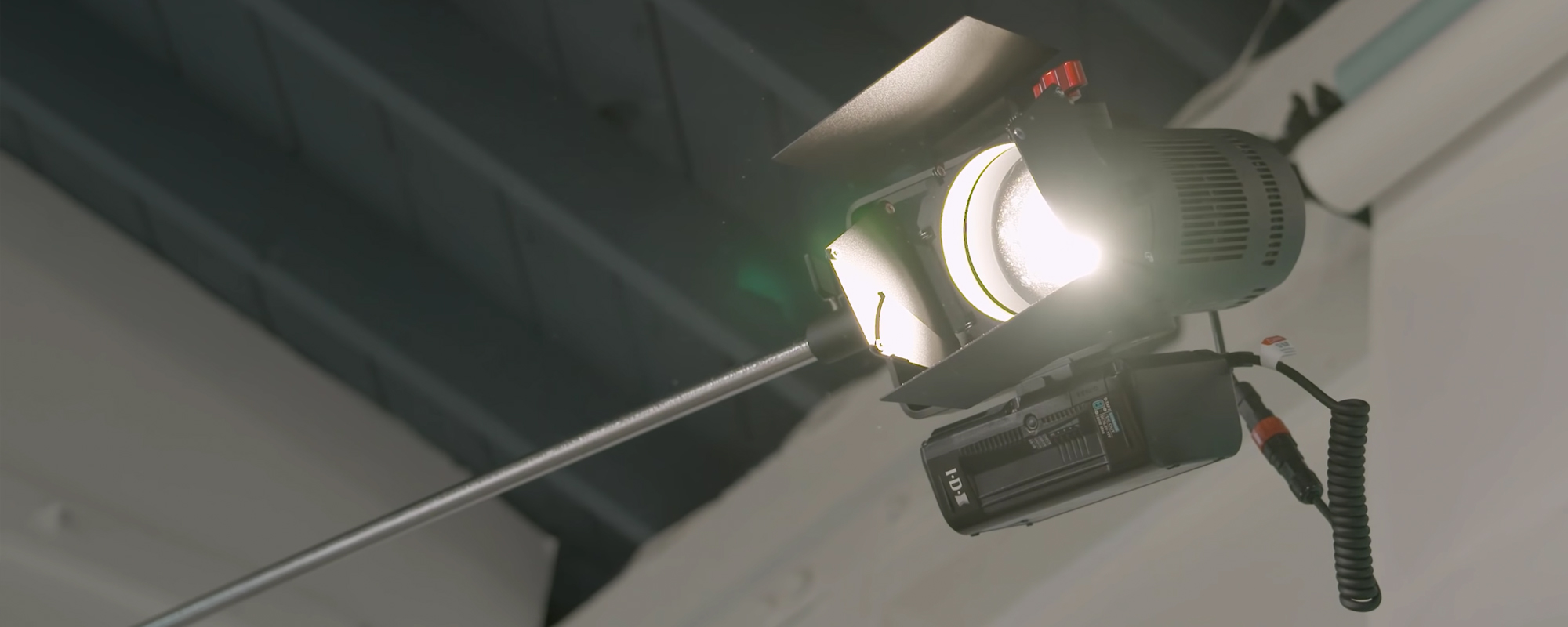 width=100% Lampa LED Aputure Light Storm LS 60x zainstalowana na statywie i podłączona do akumulatora